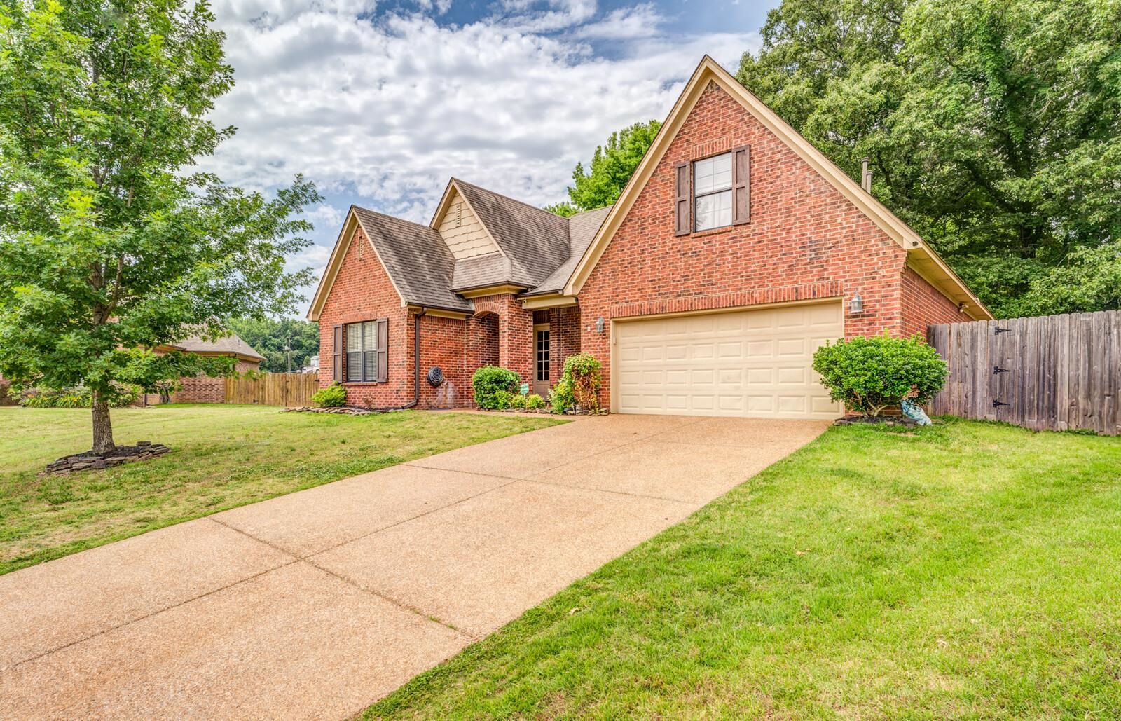 4671 Hampton Ridge Lane Bartlett, TN 38002 - Photo 4 of 40 Brick facade residence featuring a two-car garage, pitched rooflines, and a concrete driveway