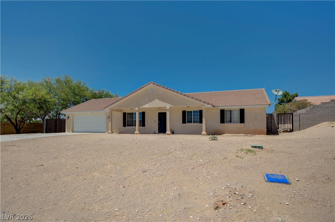 A desert oasis awaits with this single-story residence, featuring an attached garage and a welcoming covered porch.