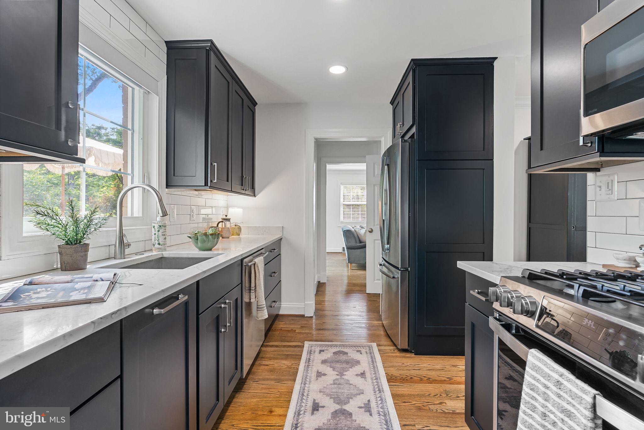 810 Grand View Drive Alexandria, VA 22305 - Photo 6 of 55 a kitchen with stainless steel appliances granite countertop a sink stove and refrigerator
