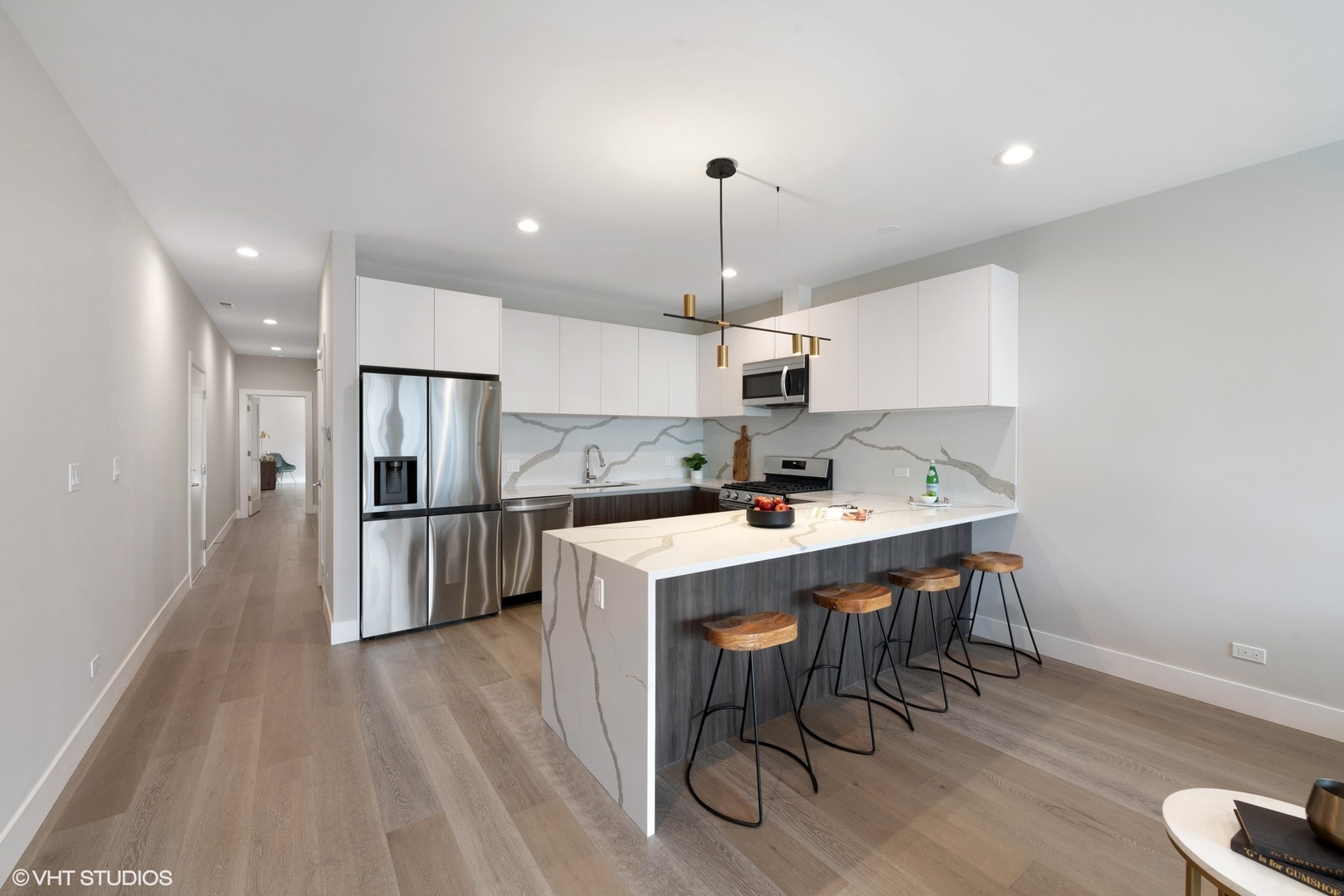 2342 West Adams Street, Unit 505 Chicago, IL 60612 - Photo 4 of 20 a kitchen with stainless steel appliances a dining table chairs stove refrigerator and cabinets