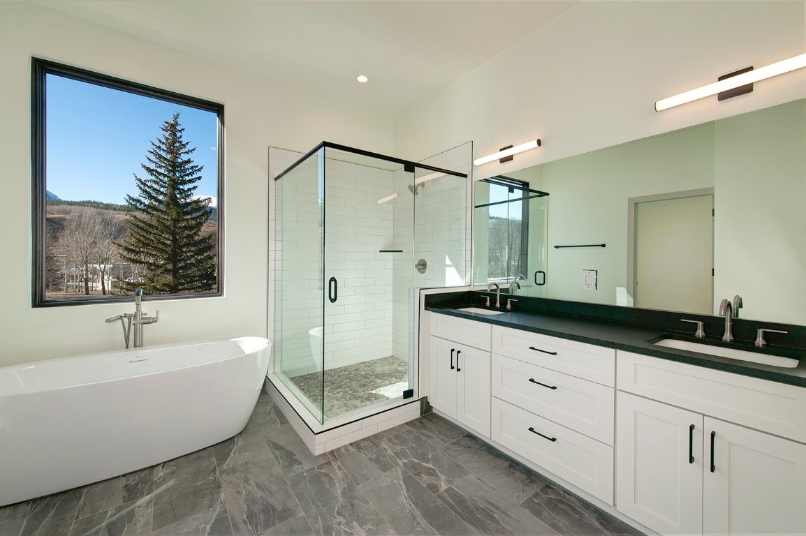 36 Geneva Drive, Unit H2 Silverthorne, CO 80498 - Photo 6 of 9 a spacious bathroom with a double vanity sink a mirror and a bathtub