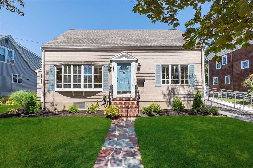 a front view of a house with a garden and plants