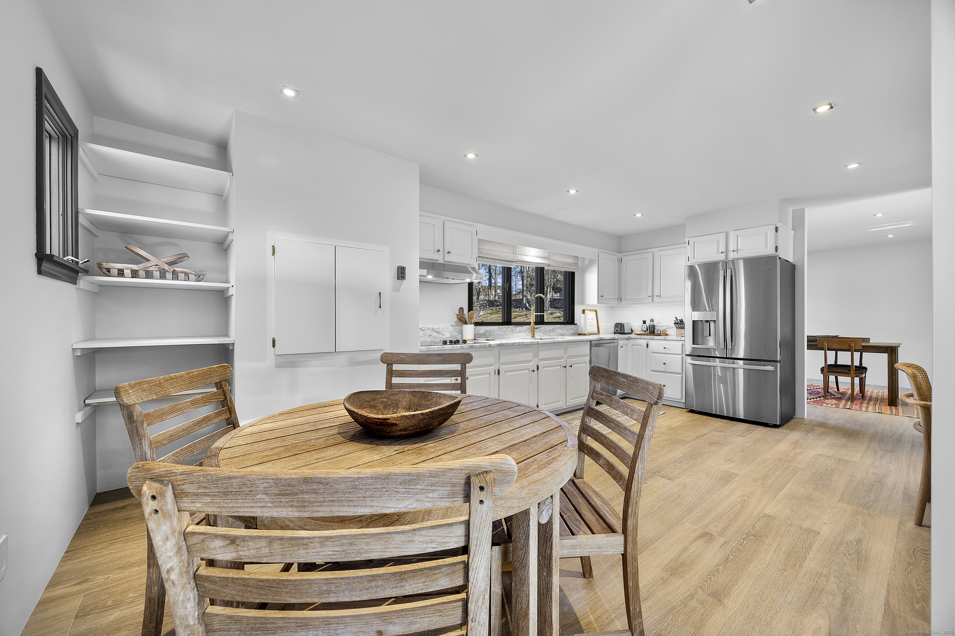 1001 Hulls Farm Road Fairfield, CT 06890 - Photo 16 of 40 a kitchen with stainless steel appliances a dining table chairs and refrigerator