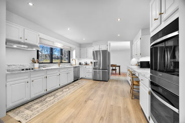 a large kitchen with cabinets stainless steel appliances and a counter top