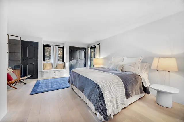 a spacious bedroom with a bed and a lamp