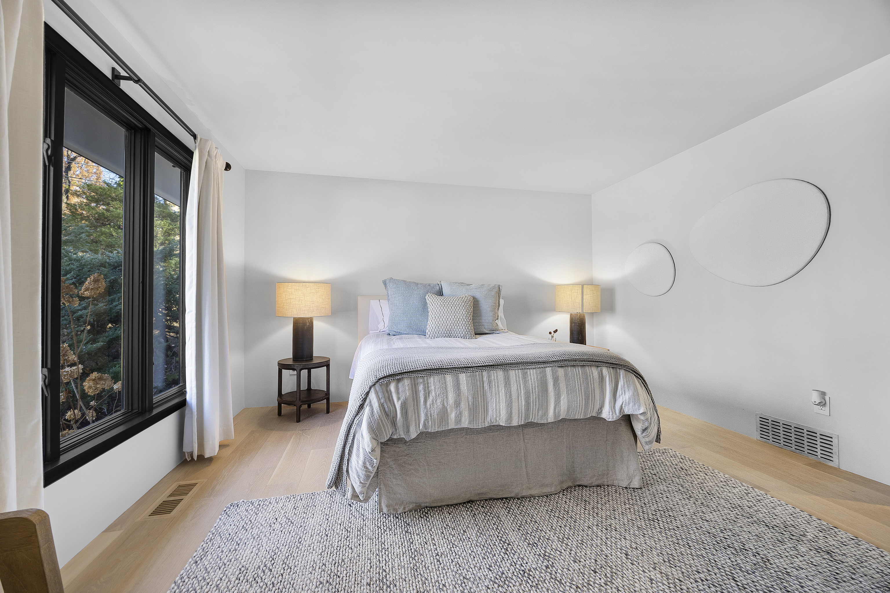 1001 Hulls Farm Road Fairfield, CT 06890 - Photo 28 of 40 a bedroom with a bed lamp and a large window