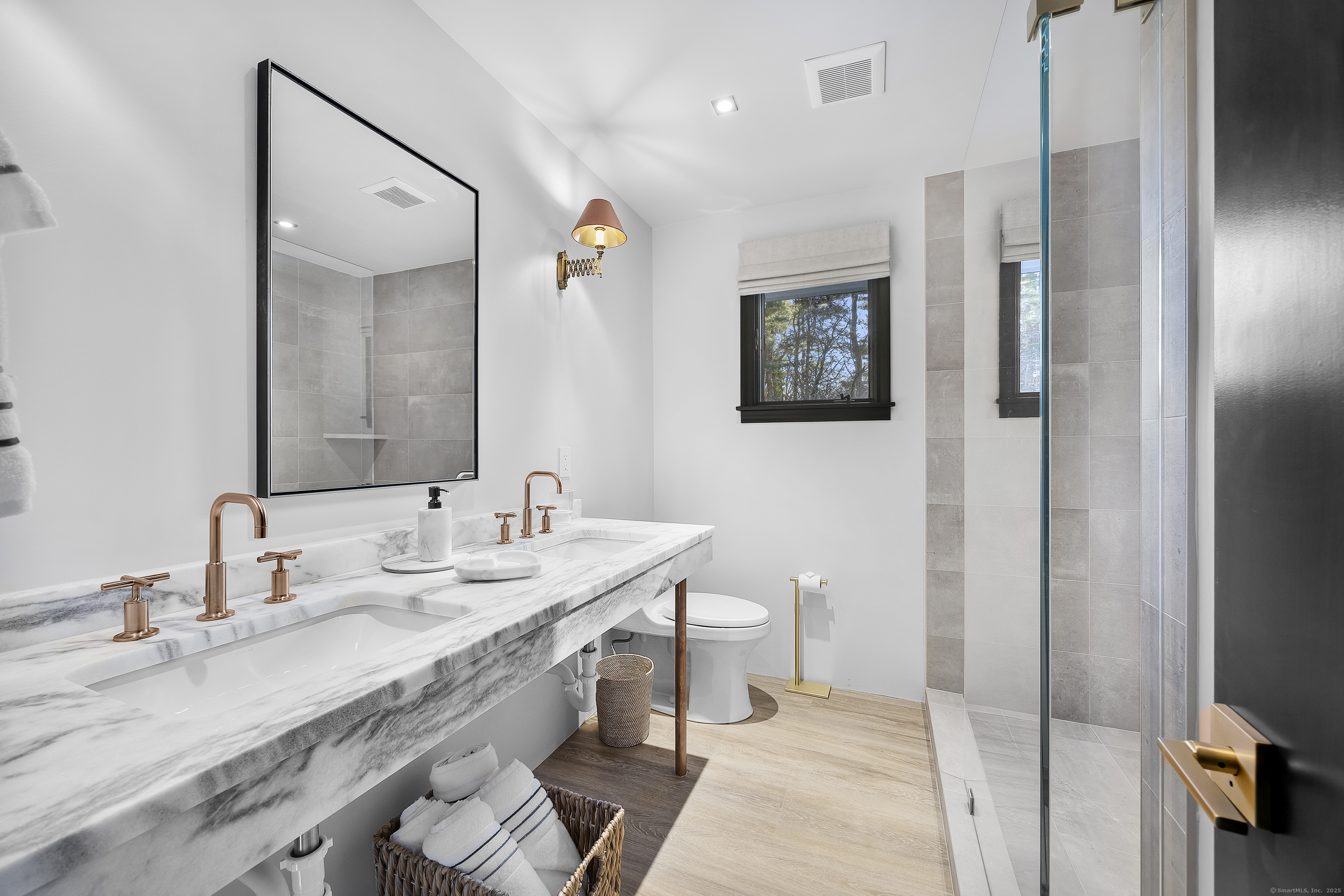 1001 Hulls Farm Road Fairfield, CT 06890 - Photo 29 of 40 a spacious bathroom with a granite countertop sink a mirror and a toilet