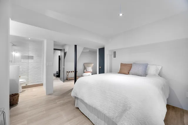 a bedroom with a bed and a large mirror