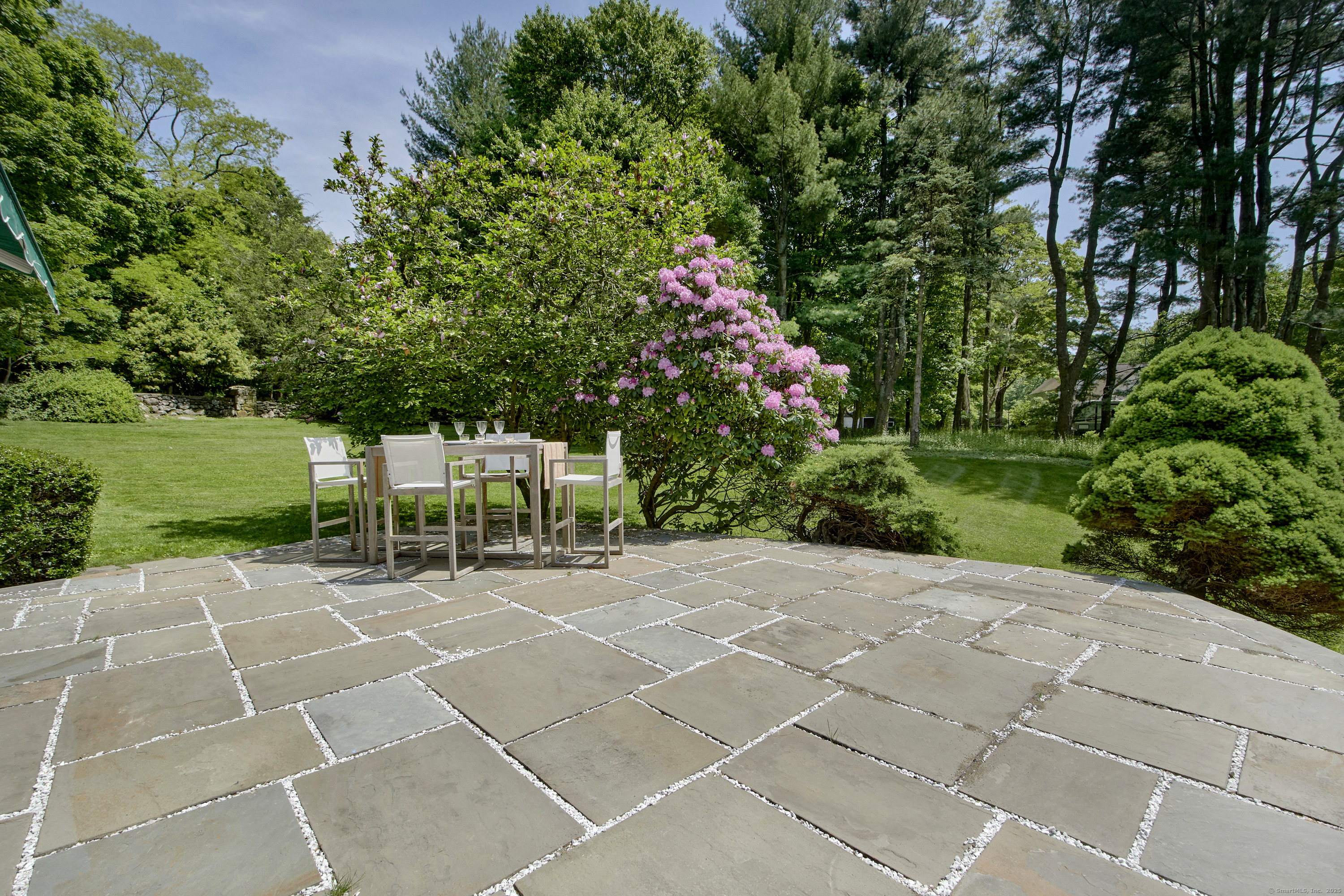 1001 Hulls Farm Road Fairfield, CT 06890 - Photo 35 of 40 a lawn chairs sitting in a yard with plants and large trees