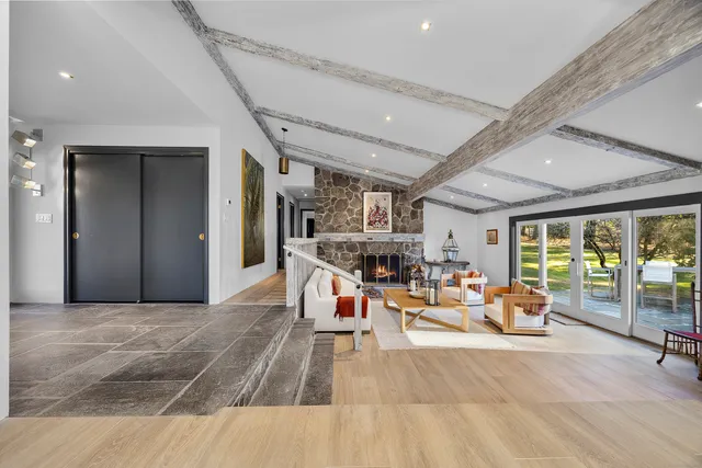 a living room with furniture a fireplace and a large window
