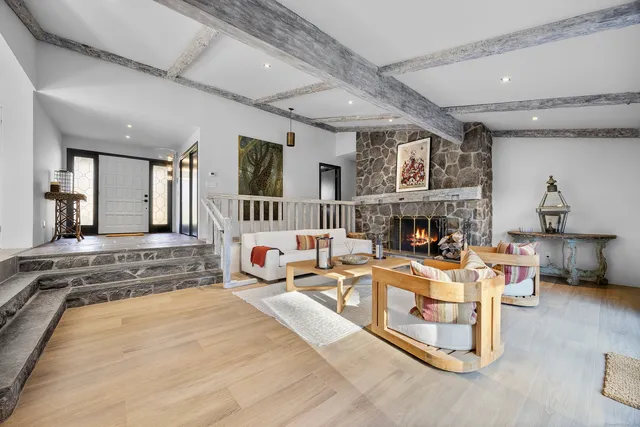 a living room with furniture a fireplace and a large mirror