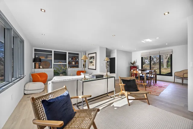 a living room with furniture a flat screen tv and a table