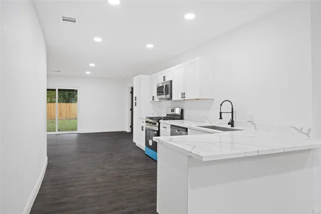 a kitchen with stainless steel appliances a sink stove and cabinets