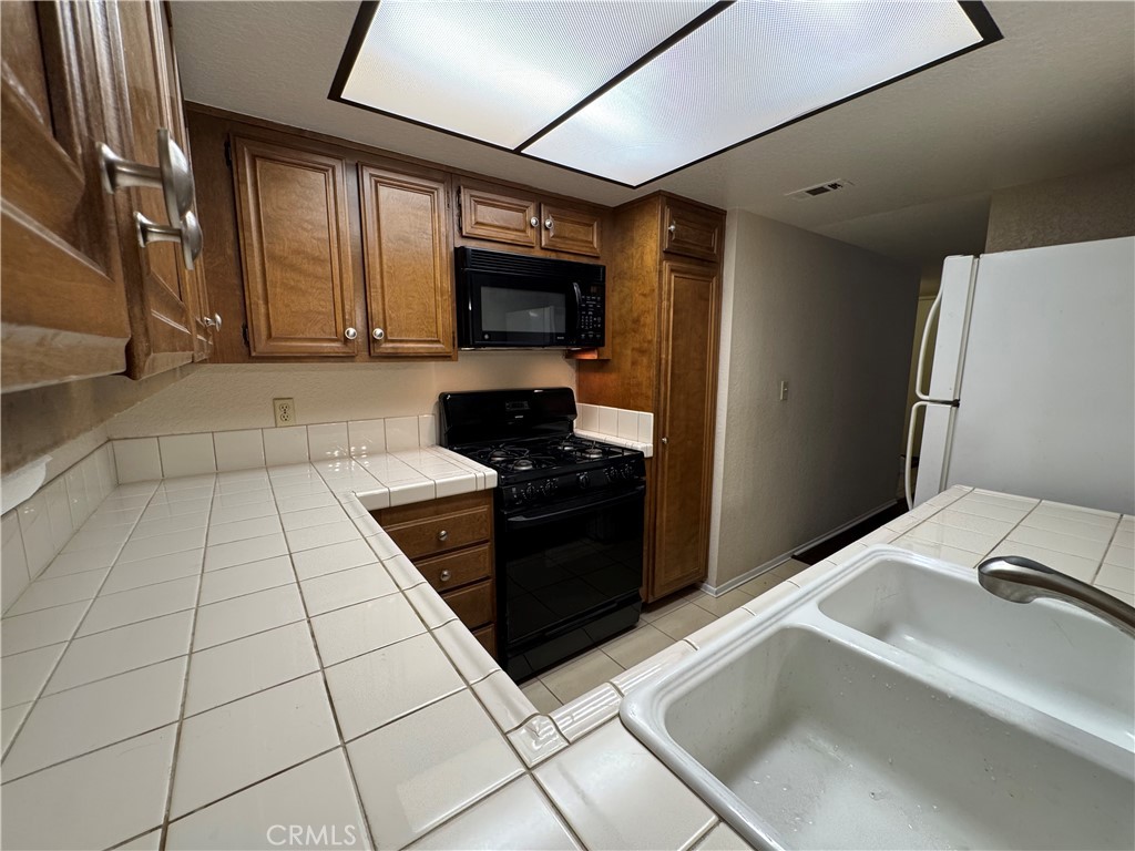 600 Central Avenue, Unit 323 Riverside, CA 92507 - Photo 10 of 25 a kitchen with washing machine and cabinets