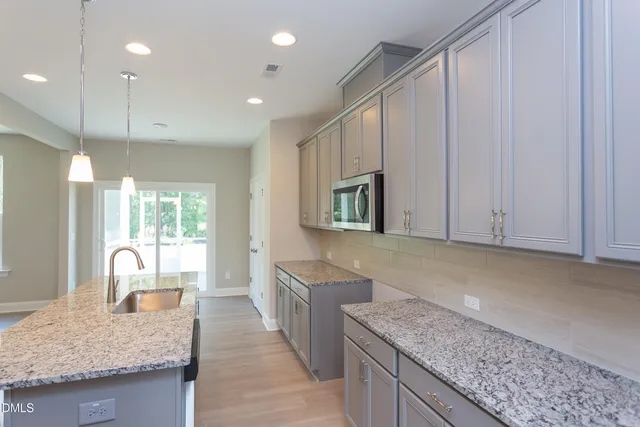 a kitchen with stainless steel appliances granite countertop wooden cabinets a oven and granite counter tops