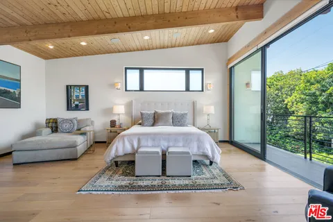 a bedroom with a bed a large window with the outer view