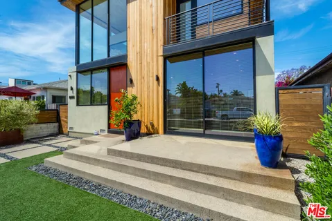 a view of a house with a potted plants and a bench in front of main door