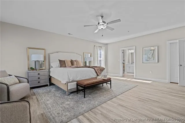 a bedroom with a bed a couch and a chandelier