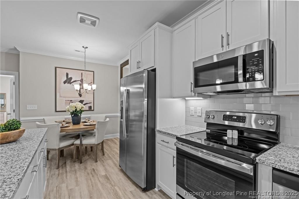 200 Gallery Drive, Unit 301 Spring Lake, NC 28390 - Photo 4 of 21 a kitchen with stainless steel appliances a stove a microwave and a refrigerator