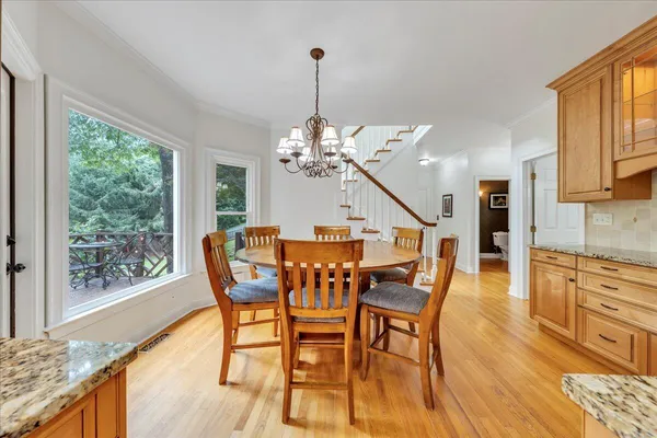 an empty room with a chandelier fan and windows