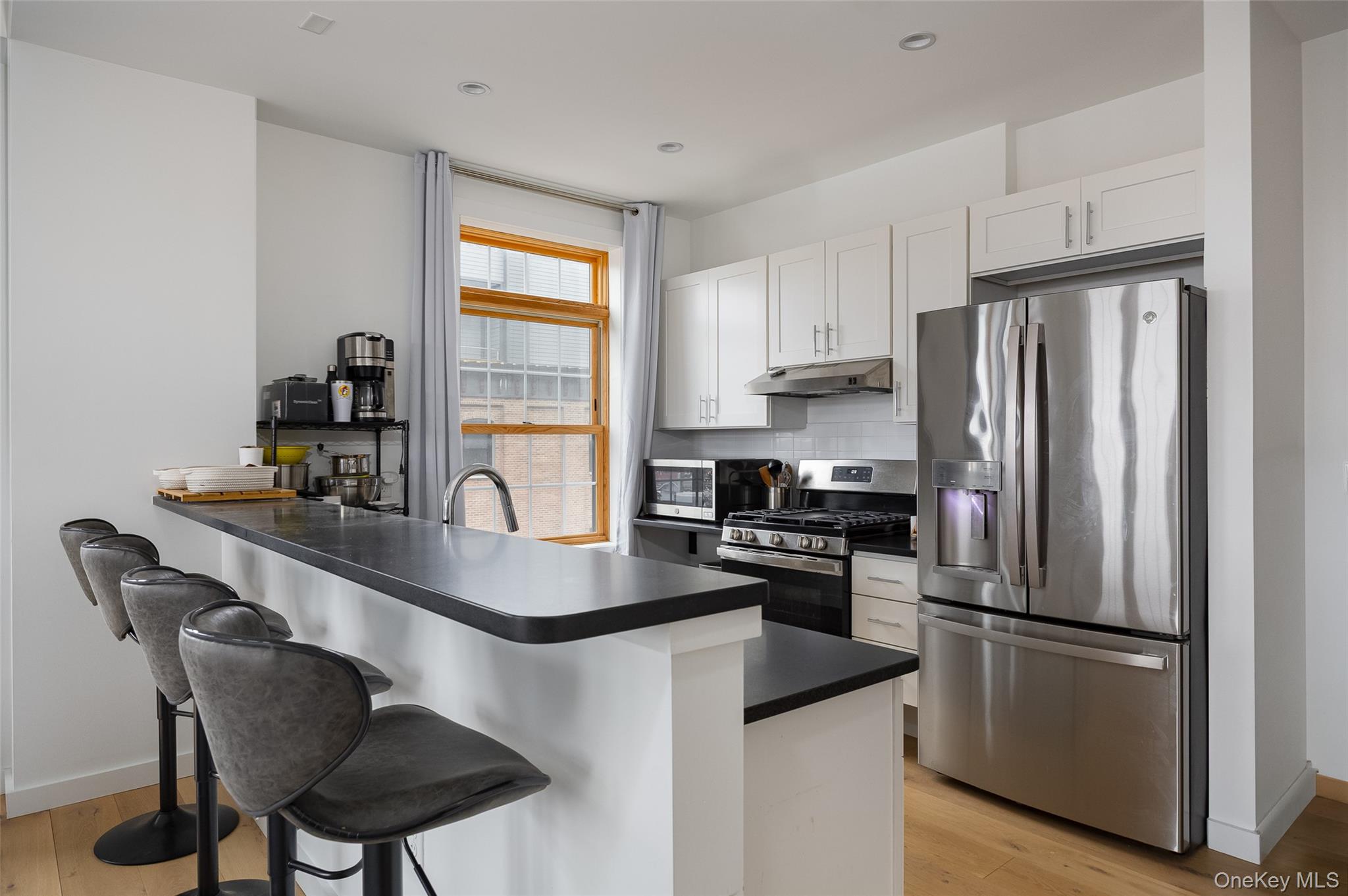 249 Main Street, Unit 312 Beacon, NY 12508 - Photo 7 of 23 a kitchen with stainless steel appliances granite countertop a refrigerator a stove a sink dishwasher and a refrigerator