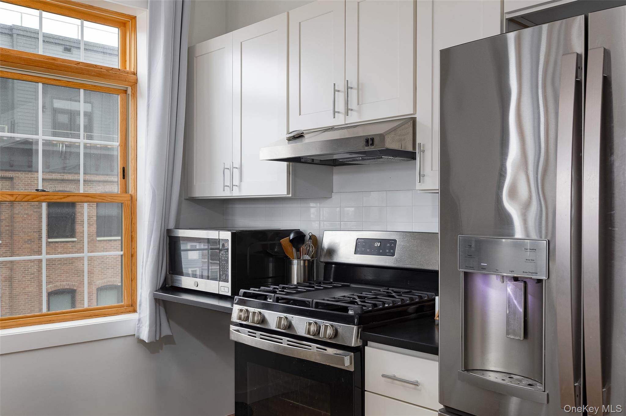 249 Main Street, Unit 312 Beacon, NY 12508 - Photo 8 of 23 a kitchen with stainless steel appliances granite countertop a stove and a refrigerator