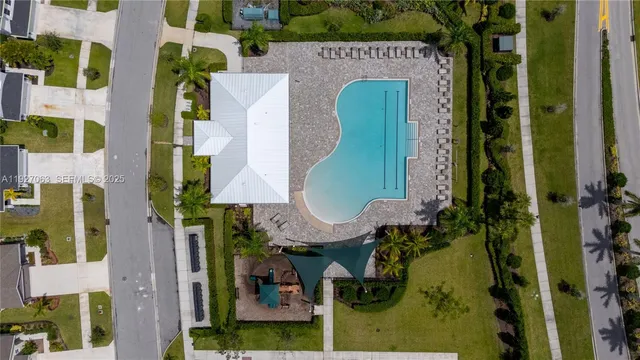 an aerial view of a house with outdoor swimming pool and sitting space