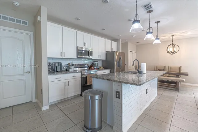 a kitchen with a sink counter top space cabinets and stainless steel appliances