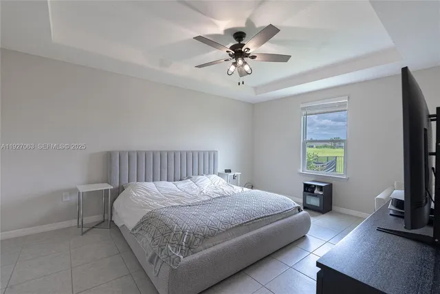 a bedroom with a bed a chandelier and a flat screen television