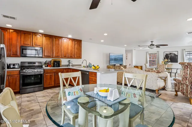 a kitchen with stainless steel appliances granite countertop wooden cabinets stove top oven a sink and dishwasher