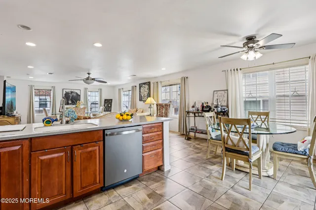 a kitchen with stainless steel appliances kitchen island granite countertop a stove a sink a dining table and chairs with wooden floor