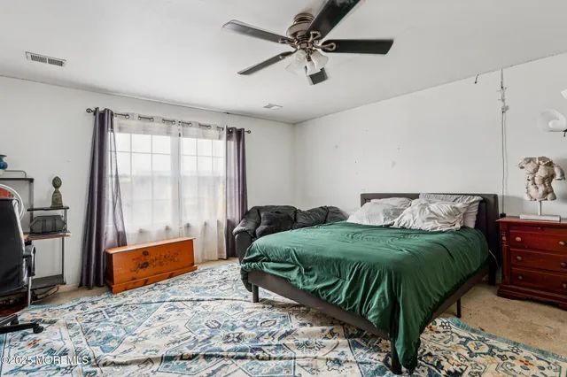 a bedroom with a bed couch and window