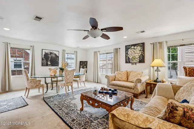 a living room with furniture kitchen view and a window