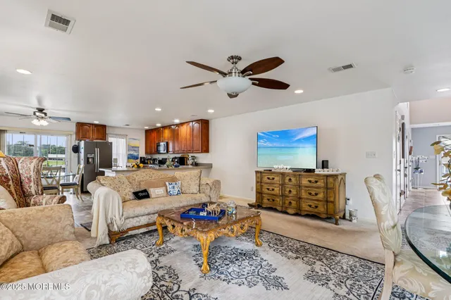 a living room with furniture kitchen view and a large window