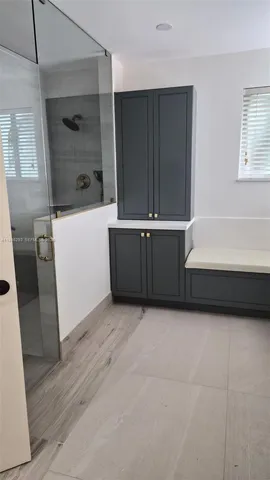 a view of an empty room with wooden floor and a cabinet