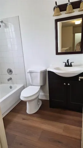 a bathroom with a toilet sink a mirror and bathtub