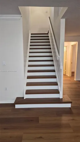 a view of entryway and hall with wooden floor