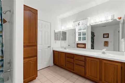 a spacious bathroom with a double vanity sink a mirror and a bathtub