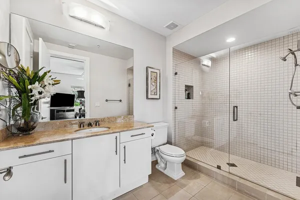 a bathroom with a sink a toilet and shower