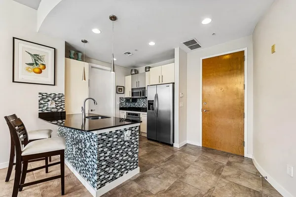a kitchen with stainless steel appliances granite countertop a refrigerator and a stove top oven