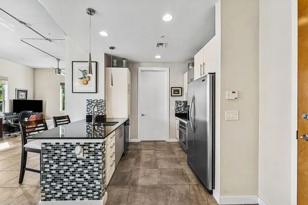 a kitchen with stainless steel appliances granite countertop a refrigerator and a stove