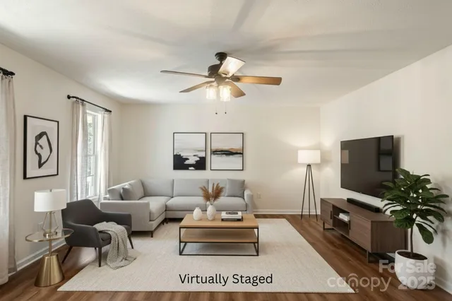 a living room with furniture a flat screen tv and a window