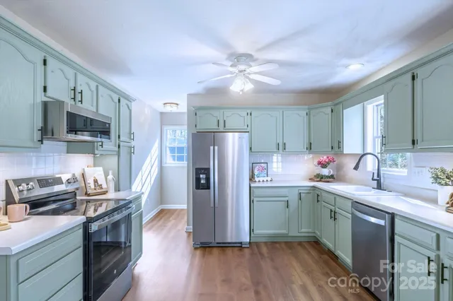 a kitchen with kitchen island granite countertop a sink appliances cabinets and counter space