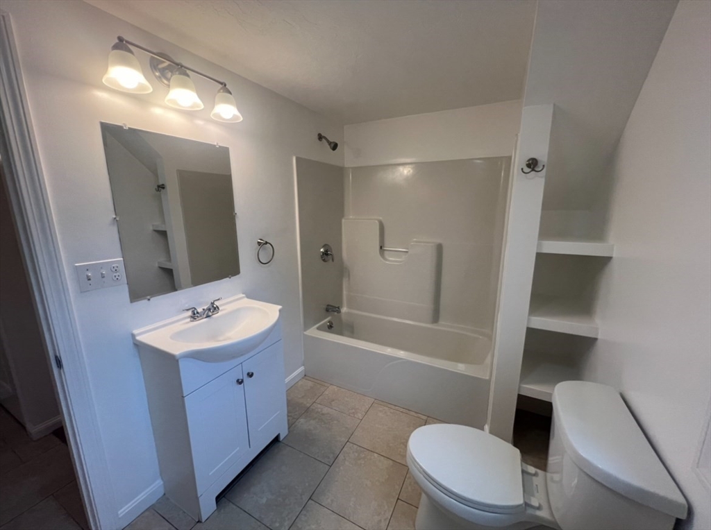 265 Dunstable Road, Unit 1 Tyngsborough, MA 01879 - Photo 6 of 6 a bathroom with a sink a toilet and shower