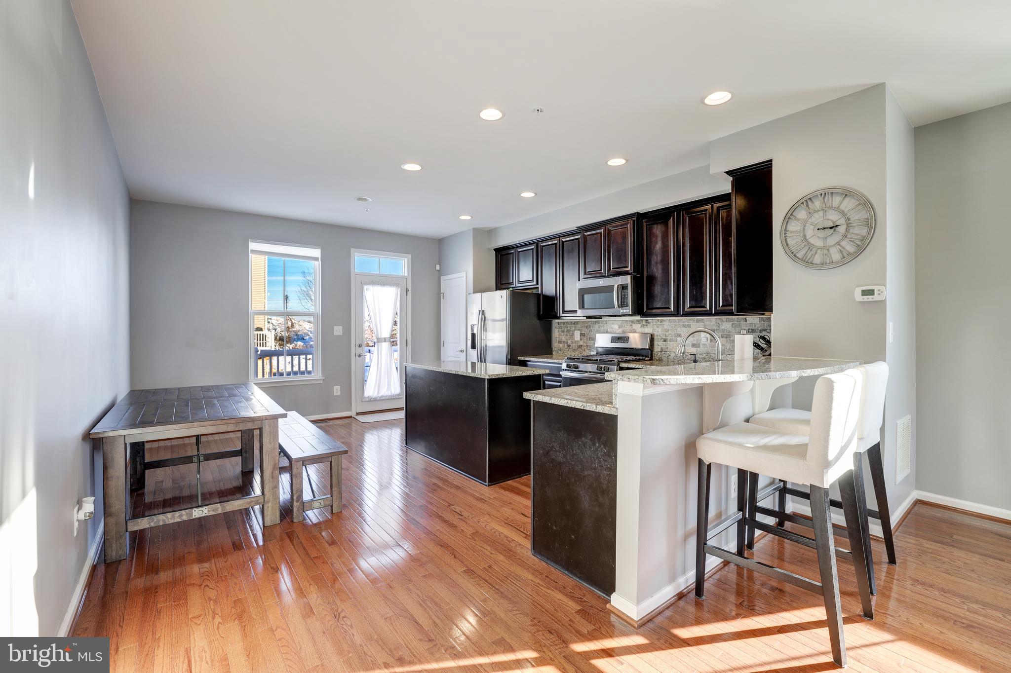 24845 Coats Square Aldie, VA 20105 - Photo 12 of 40 a living room with furniture a wooden floor and a kitchen view