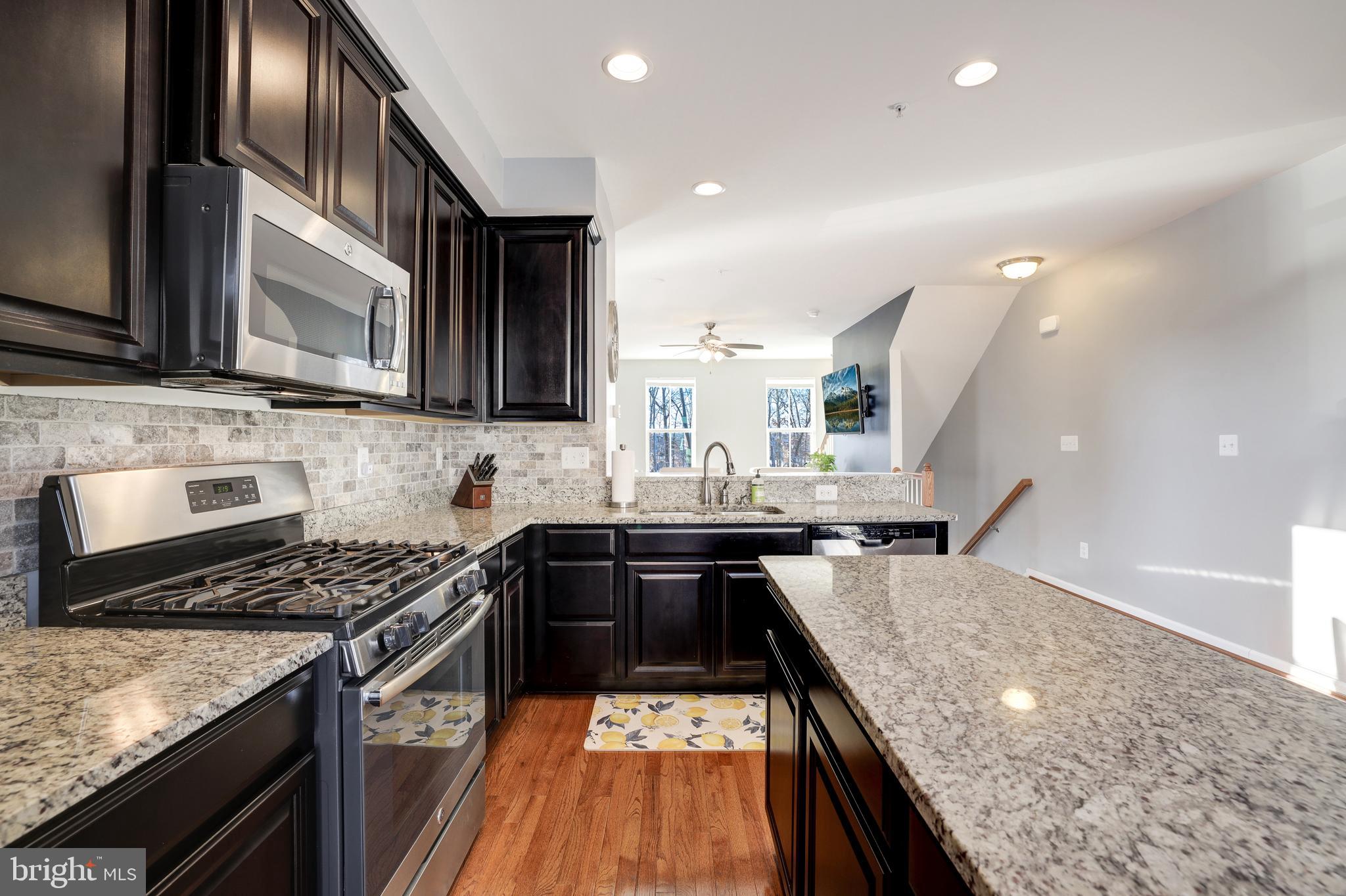 24845 Coats Square Aldie, VA 20105 - Photo 16 of 40 a kitchen with stainless steel appliances granite countertop a sink stove and refrigerator