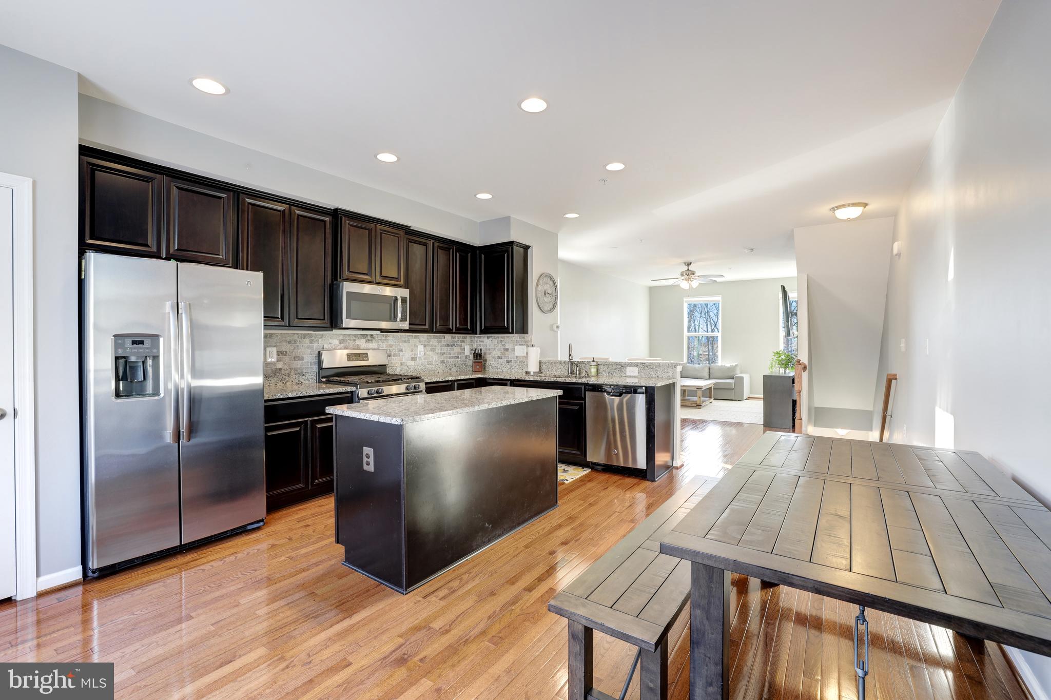 24845 Coats Square Aldie, VA 20105 - Photo 17 of 40 a kitchen with kitchen island a counter top space a sink stainless steel appliances and cabinets