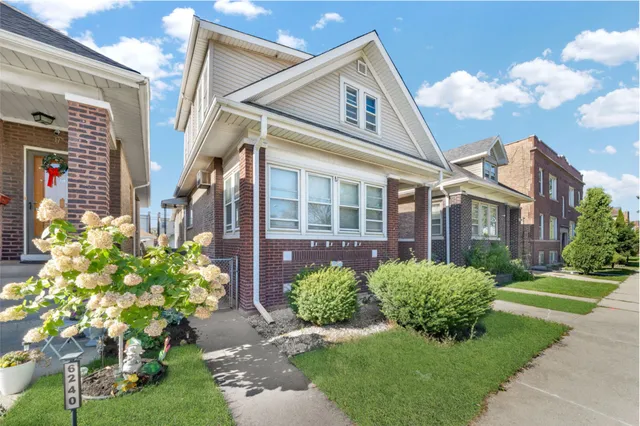 a front view of a residential houses with yard and green space