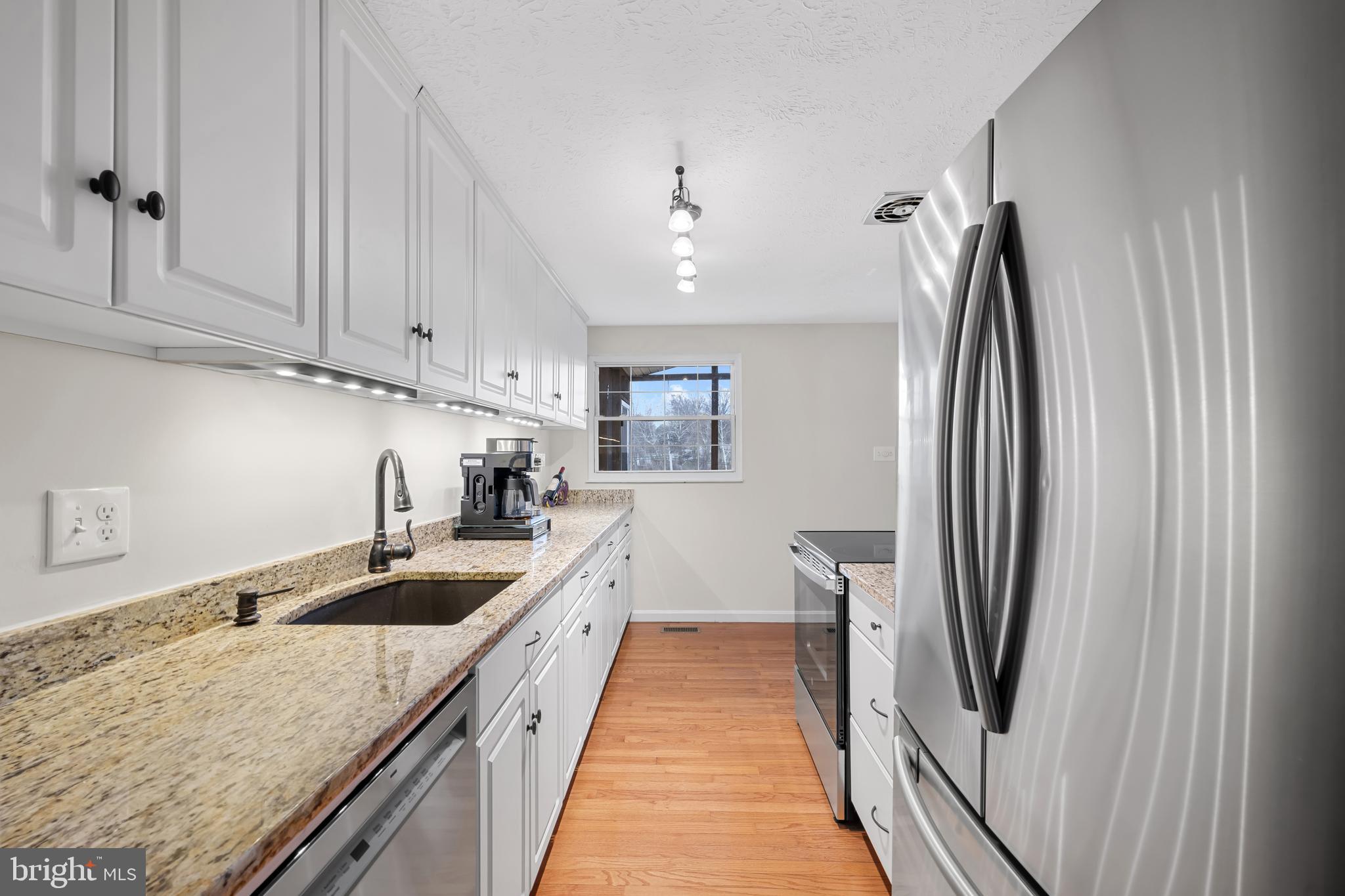 9281 Pigeon Wing Place Columbia, MD 21045 - Photo 18 of 55 a kitchen with stainless steel appliances granite countertop a refrigerator and a sink