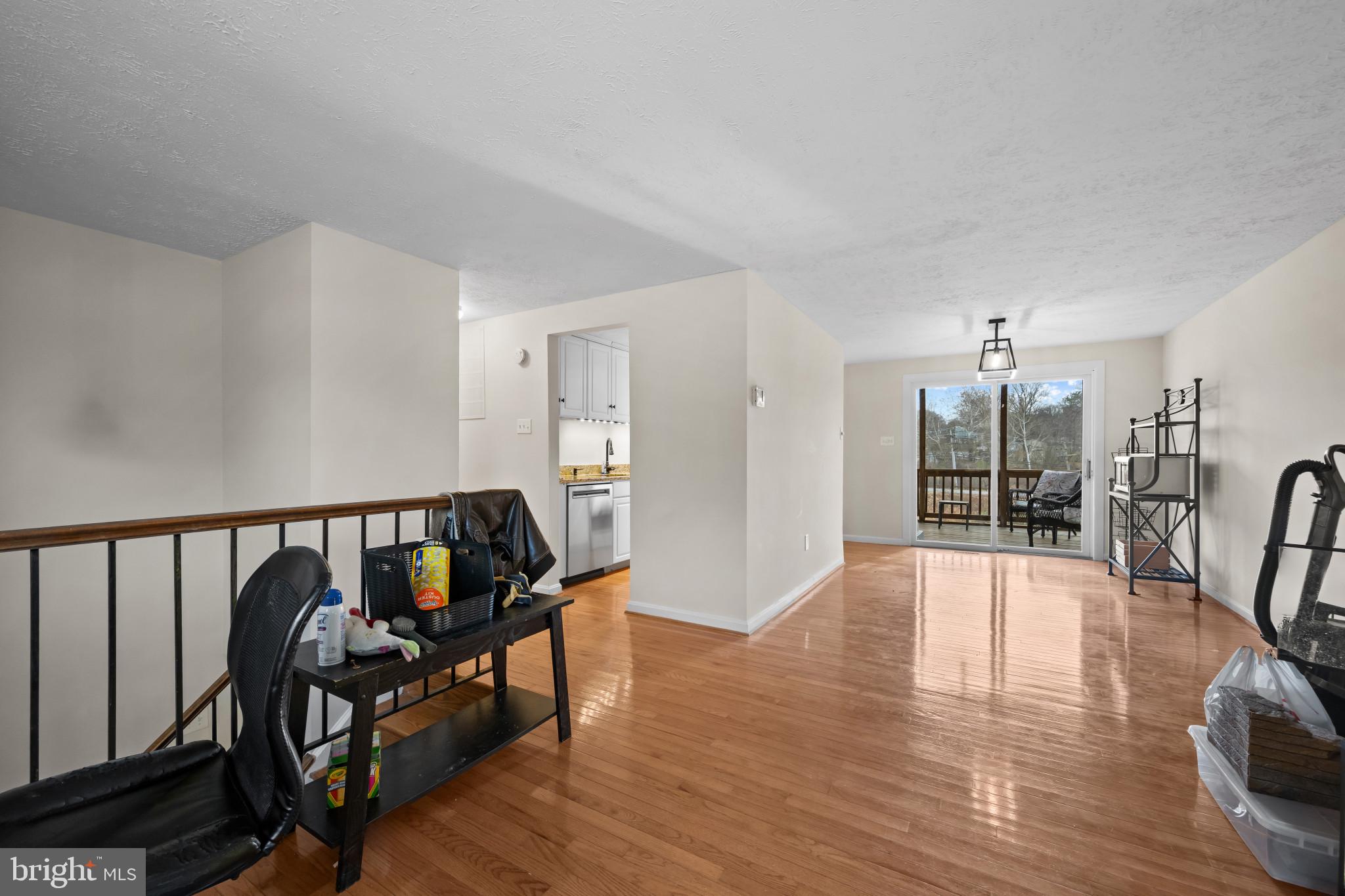 9281 Pigeon Wing Place Columbia, MD 21045 - Photo 9 of 55 a view of a hallway with wooden floor and a dining table